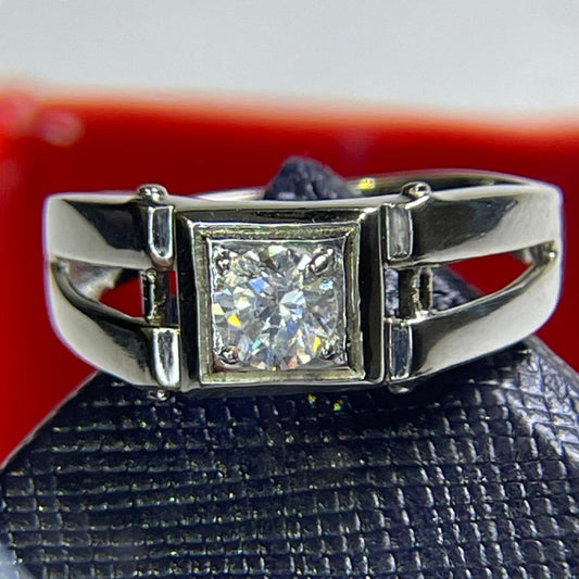 Silver ring with a diamond on a textured black surface with a red background
